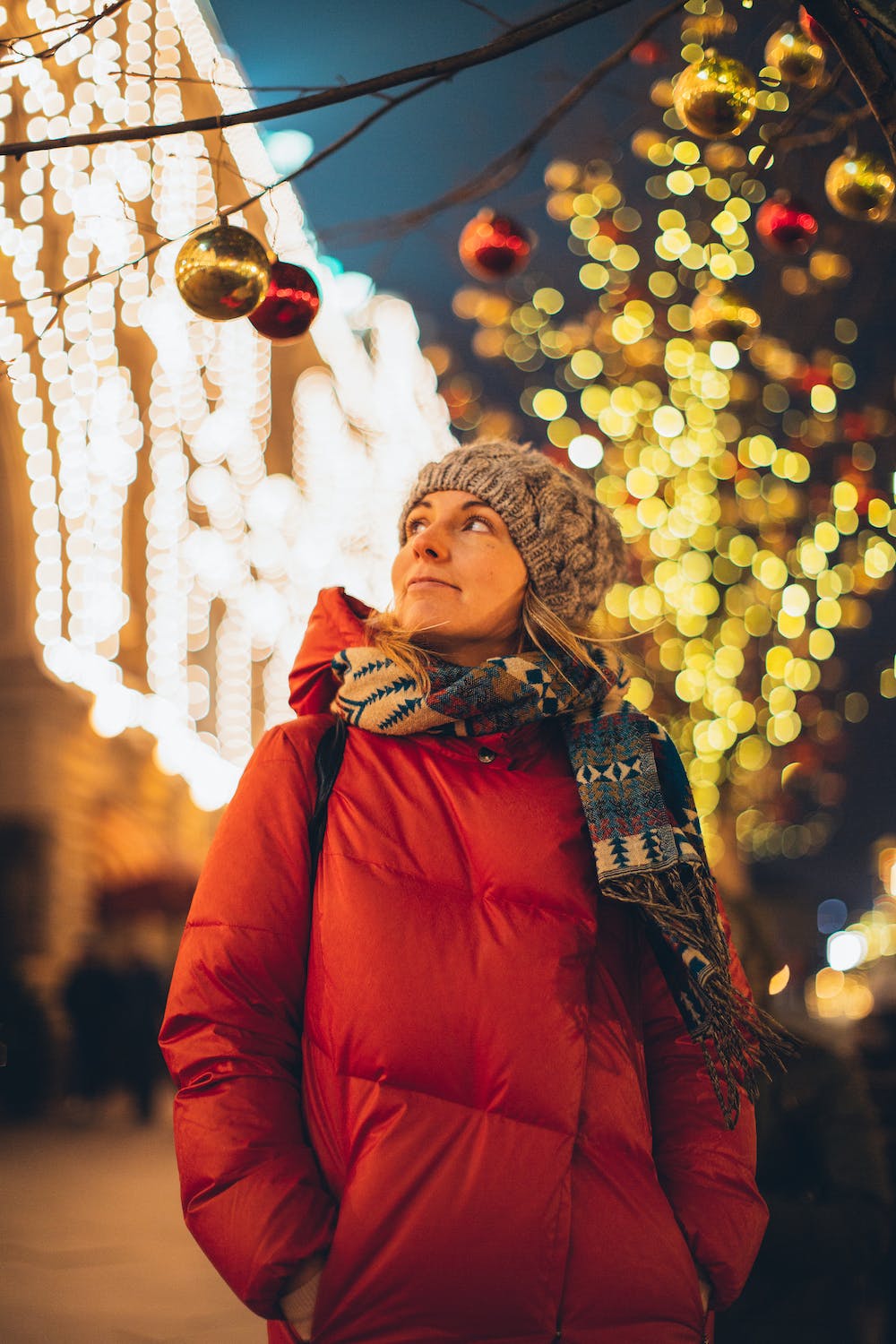 Woman smiling looking at Christmas Lights, a Reminder of Jesus, the light that he is and the Hope he brings us